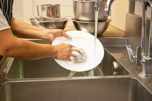 hand washing dishes in a commercial kitchen